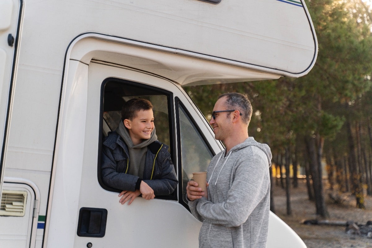 medium-shot-father-kid-with-campervan-min